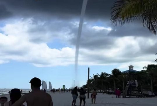 Playa del Carmen beachgoers watch large waterspout form and move over the sea