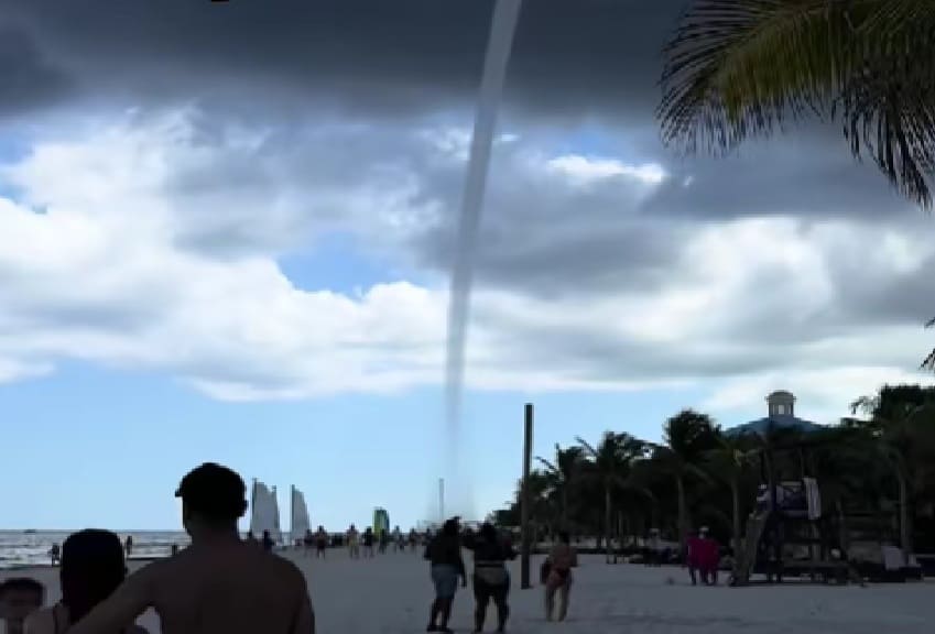 Playa del Carmen beachgoers watch large waterspout form and move over the sea